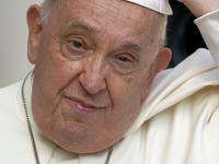 Pope Francis touches his skullcap as he arrives for his weekly general audience in St. Peter's Square at The Vatican, on August 28, 2024. (