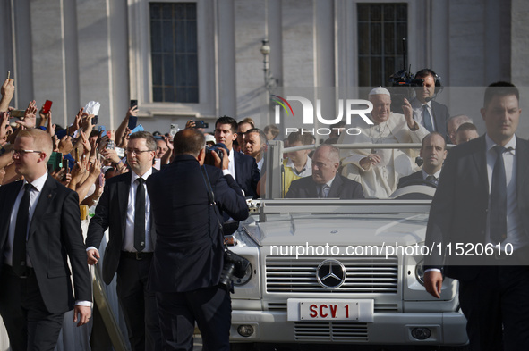 Pope Francis waves at the faithful during the weekly General Audience in Saint Peter's Square in Vatican City on August 28, 2024. 