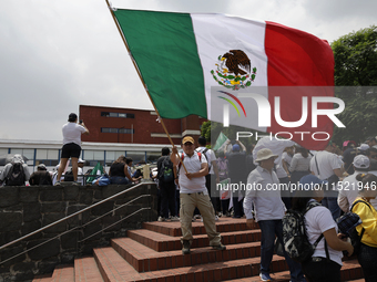 Students and workers of the Faculty of Law of the UNAM wave flags of Mexico in Ciudad Universitaria, Mexico, on August 28, 2024, to protest...