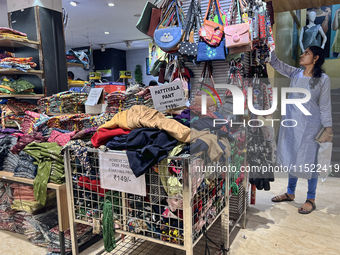 A woman looks at handbags at a textile shop in Thiruvananthapuram, Kerala, India, on April 16, 2024. (