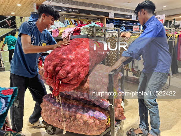 Workers move sacks of onions at a shop in Thiruvananthapuram, Kerala, India, on April 16, 2024. 