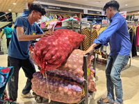 Workers move sacks of onions at a shop in Thiruvananthapuram, Kerala, India, on April 16, 2024. (