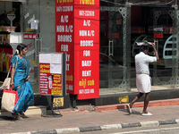 A man covers his head to protect himself from the hot sun while walking along the footpath in Thiruvananthapuram (Trivandrum), Kerala, India...