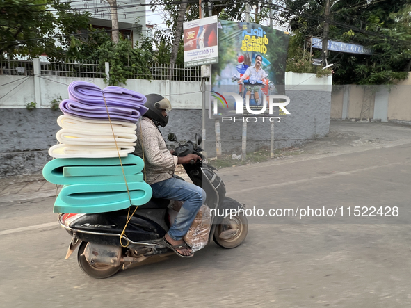 A man carries a load of foam mats on his motorbike in Thiruvananthapuram (Trivandrum), Kerala, India, on April 16, 2024. 