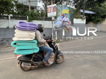 A man carries a load of foam mats on his motorbike in Thiruvananthapuram (Trivandrum), Kerala, India, on April 16, 2024. (