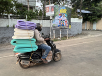 A man carries a load of foam mats on his motorbike in Thiruvananthapuram (Trivandrum), Kerala, India, on April 16, 2024. (