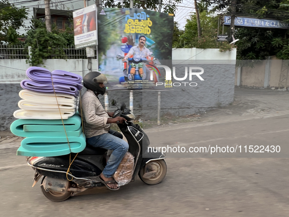 A man carries a load of foam mats on his motorbike in Thiruvananthapuram (Trivandrum), Kerala, India, on April 16, 2024. 