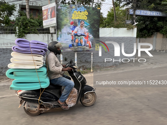 A man carries a load of foam mats on his motorbike in Thiruvananthapuram (Trivandrum), Kerala, India, on April 16, 2024. (