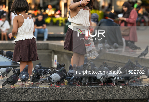 KRAKOW, POLAND - AUGUST 28:
Young visitors feed a flock of pigeons in Krakow's UNESCO Market Square as Southern Poland and Krakow endure a h...