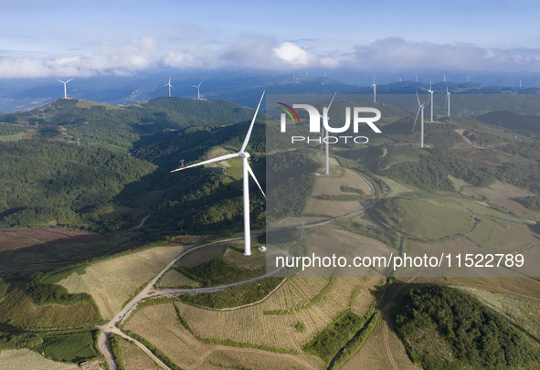 Wind turbines at a high mountain wind farm surrounded by clouds rotate against the wind in Yichang, Hubei province, China, on August 28, 202...