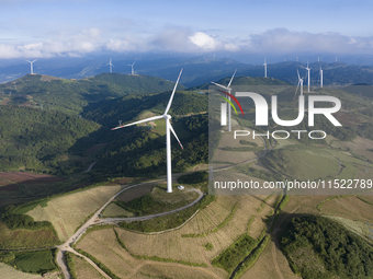 Wind turbines at a high mountain wind farm surrounded by clouds rotate against the wind in Yichang, Hubei province, China, on August 28, 202...