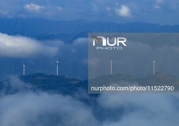 Wind turbines at a high mountain wind farm surrounded by clouds rotate against the wind in Yichang, Hubei province, China, on August 28, 202...