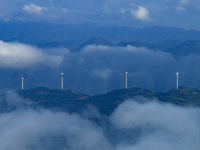 Wind turbines at a high mountain wind farm surrounded by clouds rotate against the wind in Yichang, Hubei province, China, on August 28, 202...