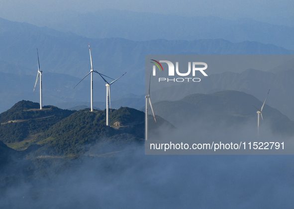 Wind turbines at a high mountain wind farm surrounded by clouds rotate against the wind in Yichang, Hubei province, China, on August 28, 202...