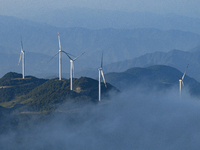 Wind turbines at a high mountain wind farm surrounded by clouds rotate against the wind in Yichang, Hubei province, China, on August 28, 202...