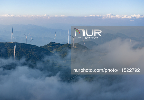 Wind turbines at a high mountain wind farm surrounded by clouds rotate against the wind in Yichang, Hubei province, China, on August 28, 202...