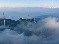 Wind turbines at a high mountain wind farm surrounded by clouds rotate against the wind in Yichang, Hubei province, China, on August 28, 202...