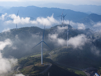 Wind turbines at a high mountain wind farm surrounded by clouds rotate against the wind in Yichang, Hubei province, China, on August 28, 202...