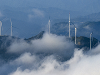 Wind turbines at a high mountain wind farm surrounded by clouds rotate against the wind in Yichang, Hubei province, China, on August 28, 202...