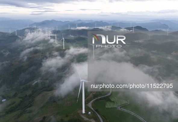 Wind turbines at a high mountain wind farm surrounded by clouds rotate against the wind in Yichang, Hubei province, China, on August 28, 202...