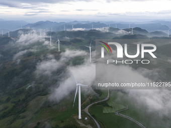 Wind turbines at a high mountain wind farm surrounded by clouds rotate against the wind in Yichang, Hubei province, China, on August 28, 202...