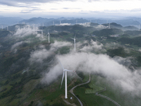 Wind turbines at a high mountain wind farm surrounded by clouds rotate against the wind in Yichang, Hubei province, China, on August 28, 202...