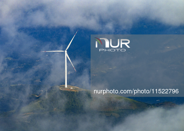 Wind turbines at a high mountain wind farm surrounded by clouds rotate against the wind in Yichang, Hubei province, China, on August 28, 202...