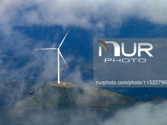 Wind turbines at a high mountain wind farm surrounded by clouds rotate against the wind in Yichang, Hubei province, China, on August 28, 202...