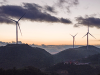 Wind turbines at a high mountain wind farm surrounded by clouds rotate against the wind in Yichang, Hubei province, China, on August 28, 202...