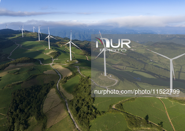 Wind turbines at a high mountain wind farm surrounded by clouds rotate against the wind in Yichang, Hubei province, China, on August 28, 202...