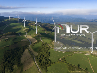 Wind turbines at a high mountain wind farm surrounded by clouds rotate against the wind in Yichang, Hubei province, China, on August 28, 202...