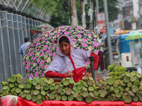 A boy holds an umbrella while waiting for customers as it rains in Srinagar, Jammu and Kashmir, on August 29, 2024. (