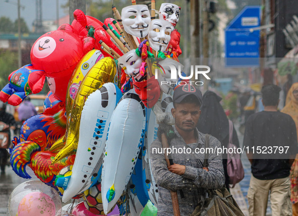 A man sells balloons as it rains in Srinagar, Jammu and Kashmir, on August 29, 2024. 