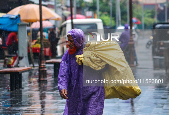 An elderly man wears a raincoat as it rains in Srinagar, Jammu and Kashmir, on August 29, 2024. 