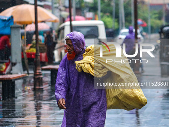 An elderly man wears a raincoat as it rains in Srinagar, Jammu and Kashmir, on August 29, 2024. (