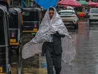 A man covers himself with a polythene sheet as it rains in Srinagar, Jammu and Kashmir, on August 29, 2024. (