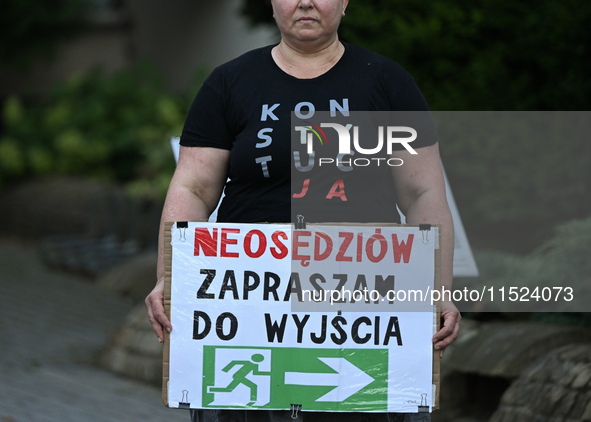 KRAKOW, POLAND - AUGUST 28:
An activist holds a placard reading 'Neo-Judges, please step down' as members of the KOD (Committee for the Defe...