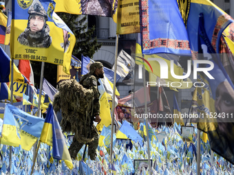 A Ukrainian serviceman commemorates his brothers-in-arms at a makeshift memorial for fallen Ukrainian soldiers on the Day of Remembrance of...