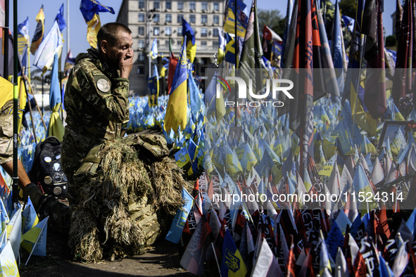 A Ukrainian serviceman commemorates his brothers-in-arms at a makeshift memorial for fallen Ukrainian soldiers on the Day of Remembrance of...