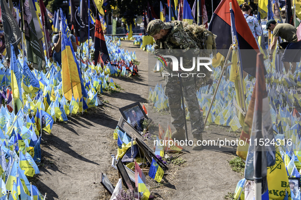 A Ukrainian serviceman commemorates his brothers-in-arms at a makeshift memorial for fallen Ukrainian soldiers on the Day of Remembrance of...