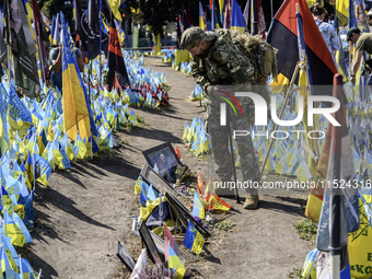 A Ukrainian serviceman commemorates his brothers-in-arms at a makeshift memorial for fallen Ukrainian soldiers on the Day of Remembrance of...