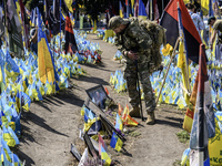 A Ukrainian serviceman commemorates his brothers-in-arms at a makeshift memorial for fallen Ukrainian soldiers on the Day of Remembrance of...