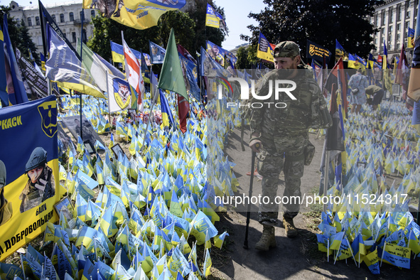 A Ukrainian serviceman commemorates his brothers-in-arms at a makeshift memorial for fallen Ukrainian soldiers on the Day of Remembrance of...