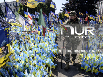 A Ukrainian serviceman commemorates his brothers-in-arms at a makeshift memorial for fallen Ukrainian soldiers on the Day of Remembrance of...