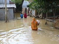 People walk in flood water in Feni District, Bangladesh, on August 29, 2024. At least 52 people are killed, a total of 43 upazilas in severa...