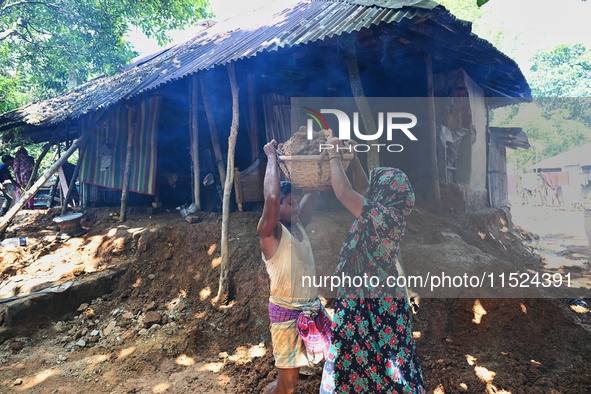 People stand in their broken house by flood water in Feni District, Bangladesh, on August 29, 2024. At least 52 people are killed, a total o...