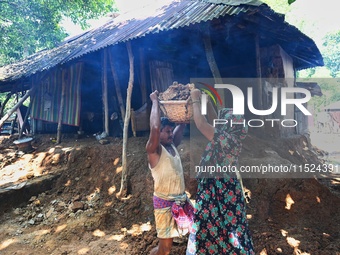 People stand in their broken house by flood water in Feni District, Bangladesh, on August 29, 2024. At least 52 people are killed, a total o...