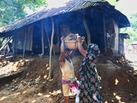 People stand in their broken house by flood water in Feni District, Bangladesh, on August 29, 2024. At least 52 people are killed, a total o...