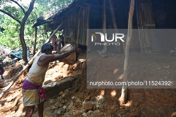 People stand in their broken house by flood water in Feni District, Bangladesh, on August 29, 2024. At least 52 people are killed, a total o...