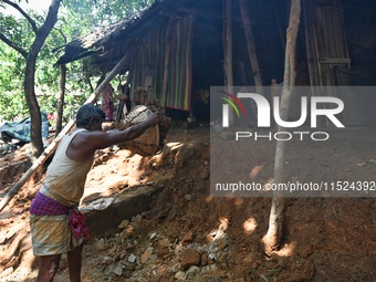 People stand in their broken house by flood water in Feni District, Bangladesh, on August 29, 2024. At least 52 people are killed, a total o...